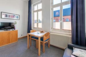 ボルクムにあるGaestehaus-St-Josef-5の小さなリビングルーム(テーブル、テレビ付)