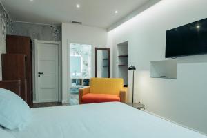 a bedroom with a bed and a yellow chair at Hôtel Casale Olmia in Moncale