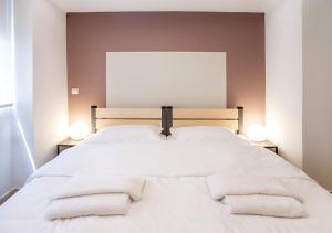 - une chambre avec un lit blanc et des serviettes dans l'établissement Snooze H, à Athènes