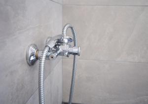 La salle de bains est pourvue d'une douche avec un tuyau. dans l'établissement Snooze H, à Athènes