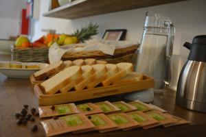 a table topped with bread and a tray of bread sticks at Ostello Casa Rossa in Laveno-Mombello