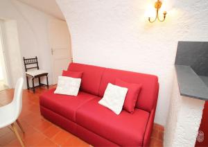 1 sofá rojo con 2 almohadas en la sala de estar en La Maison de B, en Lumio