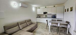 a living room with a couch and a table and a kitchen at Serendipity, La Caletta in La Caletta