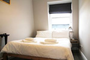 a bedroom with a bed with two towels on it at GuestReady - Quaint English Flat near Portobello in London