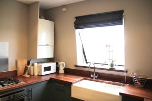 a kitchen with a sink and a microwave and a window at GuestReady - Quaint English Flat near Portobello in London