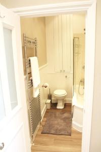 a bathroom with a toilet and a shower and a sink at GuestReady - Quaint English Flat near Portobello in London