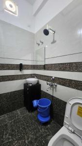 ein Bad mit einem WC und einem Waschbecken in der Unterkunft The Nines hotel & restro in Kālādhūngi