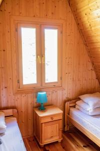 ein Schlafzimmer mit 2 Betten und einer blauen Lampe auf dem Tisch in der Unterkunft Domek letniskowy w Krasnobrodzie Roztocze in Krasnobród