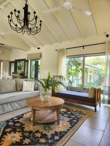 a living room with a couch and a table at SaffronStays Belle Maison - 3BR French style luxury villa with pool, bougainvillae views & alfresco dining near Kihim Beach in Alibaug