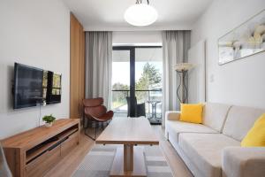 - un salon avec un canapé et une télévision dans l'établissement RentPlanet - Apartamenty Shellter, à Rogowo