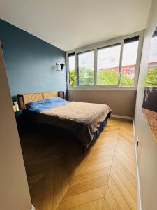 Un pat sau paturi într-o cameră la Apt Buttes Chaumont vue Paris