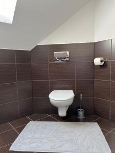 uma casa de banho com um WC e uma parede de azulejos em Apartmán Krahule em Krahule