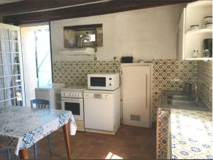 a kitchen with a stove and a sink and a table at Pîgeonnier du Rau, avec Parc et Piscine 1-1 in Gamarde-les-Bains +13 photos