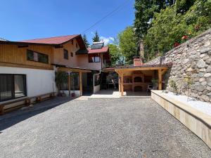 Un camino de entrada que conduce a un edificio con un muro de piedra. en MaDaS, en Bărbăteşti