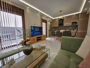 a living room with a couch and a tv at Agora Luxury Villa I in Loutraki