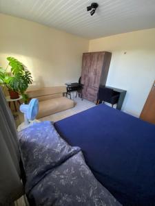 - une chambre avec un lit bleu et un canapé dans l'établissement Nosso lar em Natal - quarto, à Natal
