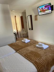 1 dormitorio con 1 cama grande y 2 toallas. en Alojamiento La Escalera, en Alhama de Granada