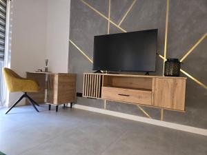 a living room with a television on a wooden entertainment center at Kolo Apartament Gold in Koło