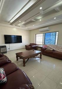 a living room with couches and a flat screen tv at Tlaa al ali amman 3 rooms furnished apartment المحكمة الدستورية in Umm Uthainah