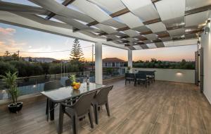 un patio con tavolo e sedie su un ponte di Villa Agaliou by "elite" a Ambelókipoi