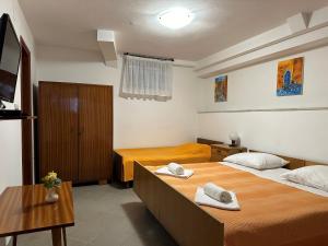 Habitación de hotel con 2 camas y mesa en Apartment Bilić, en Pula