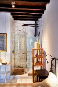 um chuveiro de vidro num quarto com uma parede de pedra em CR La Posada de los Sentidos em Jarandilla de la Vera