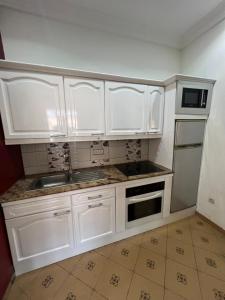 uma cozinha com armários brancos e um lavatório em Holiday Appartment Elbe em Lomé