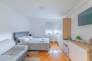 uma sala de estar com uma cama e um sofá em Apartman Nora em Čakovec