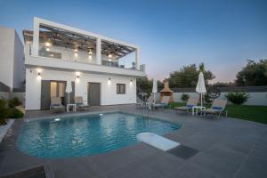 una villa con piscina di fronte a una casa di Villa Agaliou by "elite" a Ambelókipoi