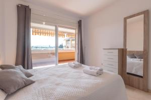 a bedroom with a large bed with towels on it at Aguamarina Gamonal in Marbella