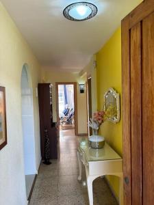un corridoio con un tavolo con un vaso di fiori sopra di Acogedor Apartamento Cullera 200 metros playa a Cullera