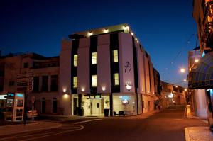 a black and white building on a street at night at Benavente Vila Hotel in Benavente