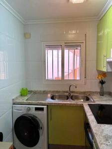 una cucina con lavello e lavatrice di Acogedor Apartamento Cullera 200 metros playa a Cullera Altre 47 foto
