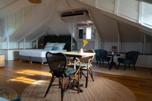 Cette chambre comprend un lit, une table et des chaises. dans l'établissement Couleur Locale Paramaribo, à Paramaribo