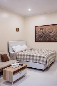 1 dormitorio con cama, sofá y mesa en Light House Residence Denpasar Bali, en Denpasar