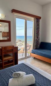 a bedroom with a bed and a view of the ocean at Stegna Sea & Sun in Archangelos