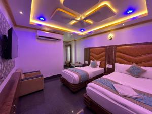 um quarto de hotel com duas camas e uma televisão em HOTEL COUNTRY INN em Dimāpur