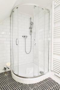 a shower with a glass door in a bathroom at Apartments am Wellenreiter in Tating