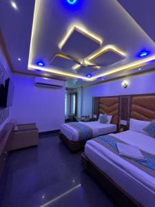 um quarto de hotel com duas camas e iluminação roxa em HOTEL COUNTRY INN em Dimāpur