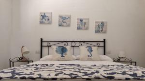 a bedroom with a bed with four pictures on the wall at Lazulite - Sardinia Suite in Murta Maria +17 photos