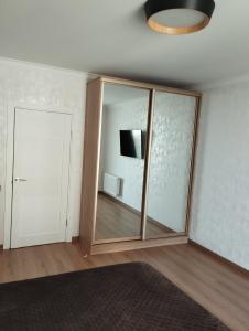 um quarto com um espelho, uma televisão e uma porta em VIP квартира однокімнатна em Lutsʼk