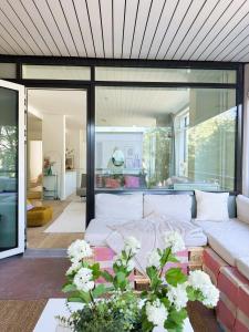 ein Wohnzimmer mit einem weißen Sofa und ein paar Blumen in der Unterkunft New luxury 110sqm apartment with terrace and great location in Helsinki