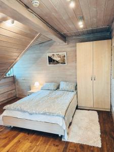 a bedroom with a bed and a wooden ceiling at Vila Ambasada in Šventoji