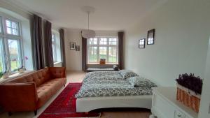 een slaapkamer met een bed en een bank bij Apartment in Danmark -Petersminde Exclusive Apartments in Otterup