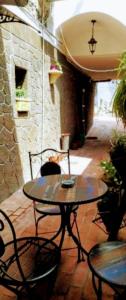 un patio con mesa, sillas y pared de piedra. en Da Giulietta, en Adrano