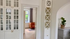 a hallway with white cabinets and a living room at Apartment in Danmark -Petersminde Exclusive Apartments in Otterup