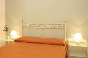 カポリーヴェリにあるLo Scoglio - Goelbaのベッドルーム1室(オレンジのシーツとランプ2つ付)