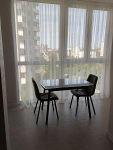 einen Esstisch und Stühle vor einem Fenster in der Unterkunft VIP квартира ЖК Київ Скай Рівненська, 4 in Luzk + 3 Fotos