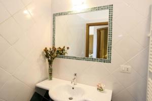 a white bathroom with a sink and a mirror at Lo Scoglio - Goelba in Capoliveri