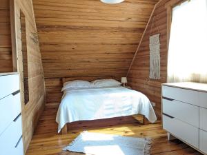 ein Schlafzimmer mit einem Bett in einer Holzwand in der Unterkunft Domki nad morzem Kąty Rybackie in Kąty Rybackie